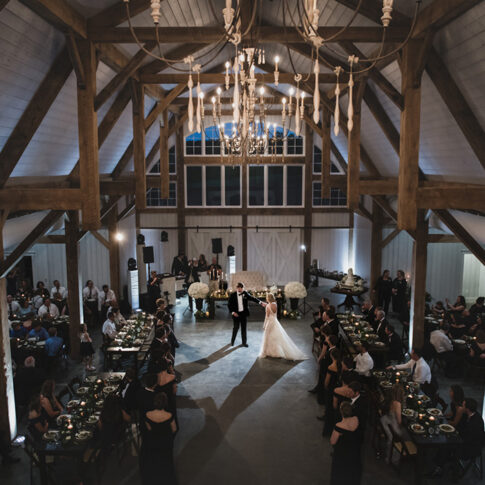 A bride and groom dance at their barn wedding reception.