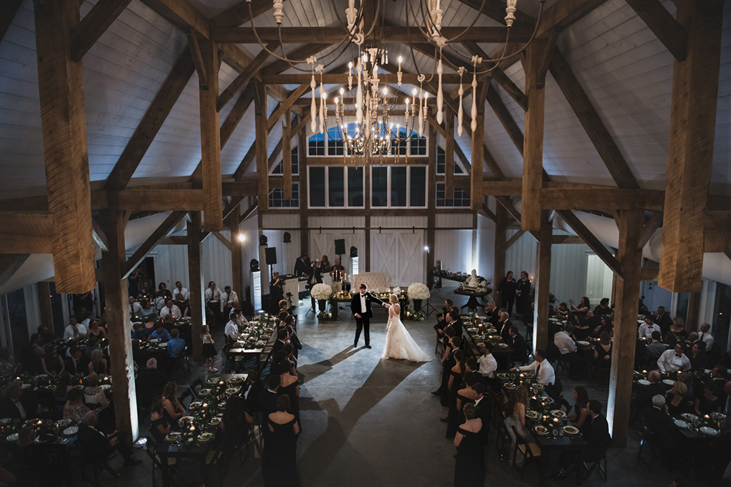 A bride and groom dance at their barn wedding reception.