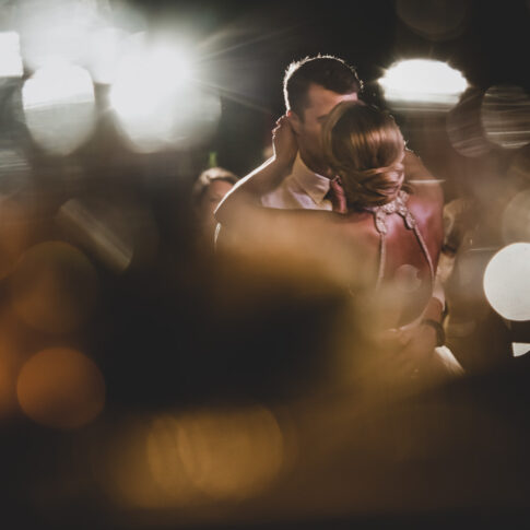 Husband and wife kiss during their first dance.