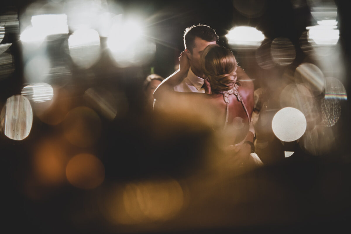 Husband and wife kiss during their first dance.