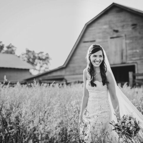 Bride walks through hayfield