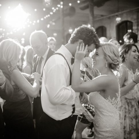 In a shot taken at the Charelston, SC Cigar Factory, the bride laughs as she is dancing with her new husband during the lively reception.