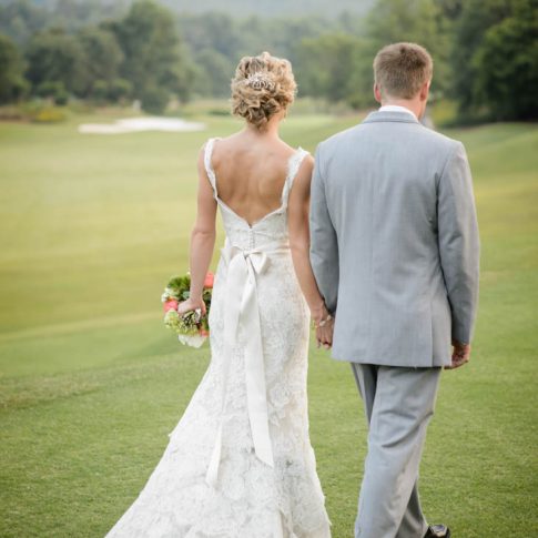 Newlyweds casually stroll over the golf course at the Cliffs at Glassy Mountain shortly after their nuptials.