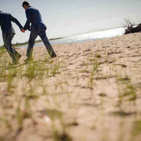 The happy new grooms walk across the beautiful beach of Fire Island shortly after their ceremony.