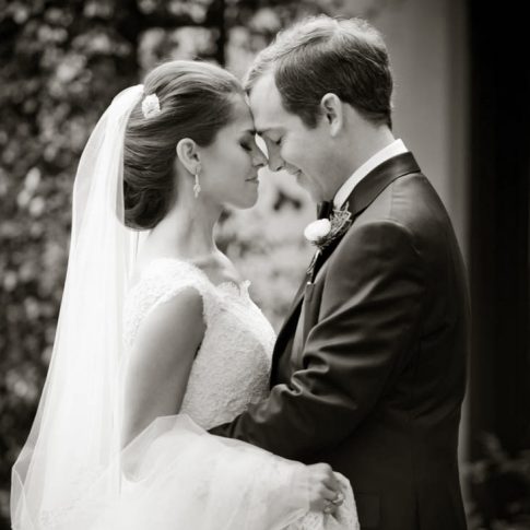 A groom and bride embrace each other in a moment of prayer before the commencement of the wedding ceremony.