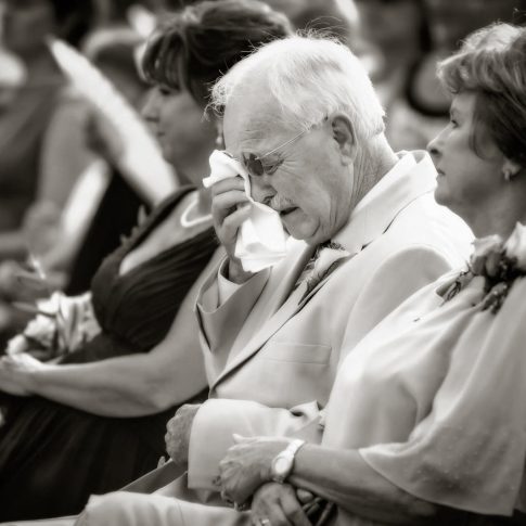 A grandfather takes a moment to dry his tears during the ceremony with his handkerchief.