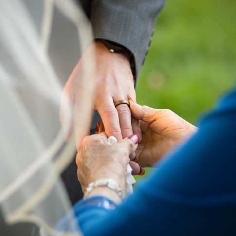 A grandmother pauses to admire the grooms new wedding ring.