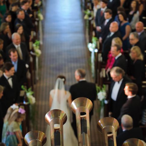 A detail shot of the horns in a chapel as they play while the bride and her father proceed down the aisle.