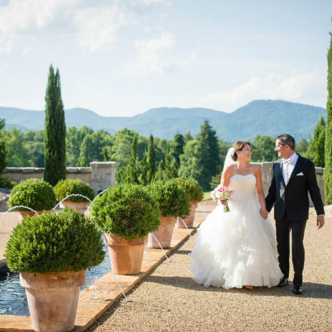 A bride and groom join hands as they take a stroll around the fountains of Hotel Domestique in Travelers Rest, SC.