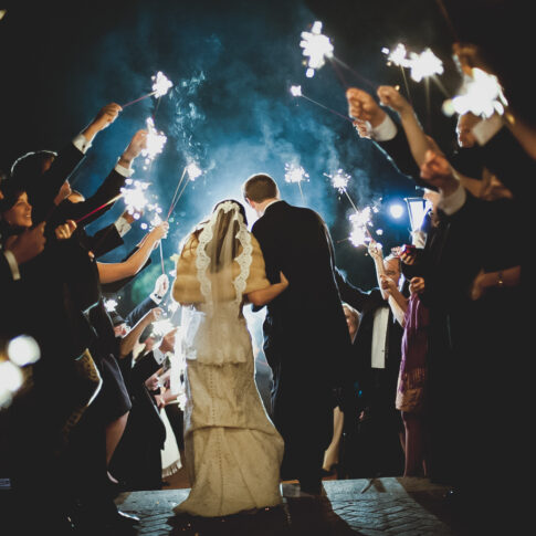 Husband and wife exit the Poinsett Club through a tunnel of sparklers