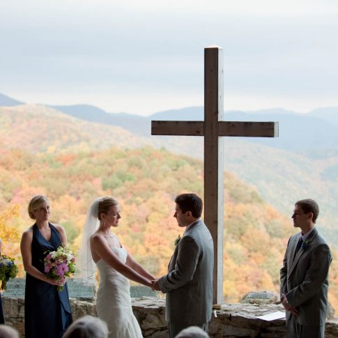 The bride and groom stand, holding hands, at Pretty Place, NC, during their wedding vows.