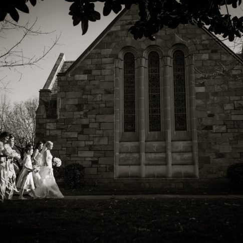 The bride and her bridesmaids walk toward the chapel before the ceremony begins.