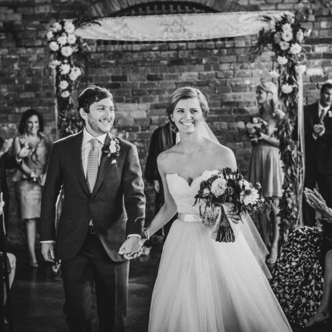 The new husband and wife walk down their aisle during their wedding recessional.