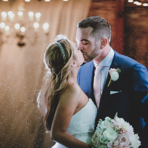 The bride and groom share a kiss as they stand in the beautiful Wyche Pavilion in downtown Greenville, SC.