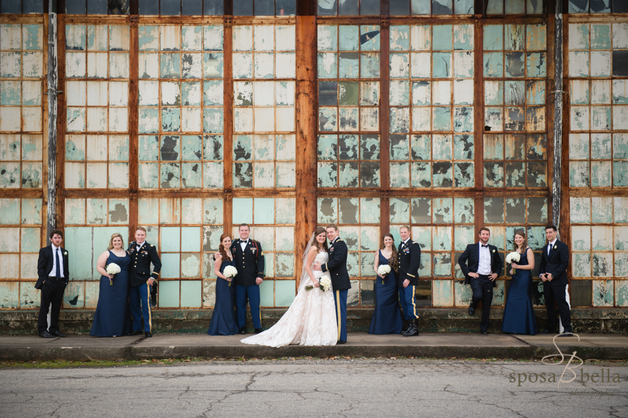 The rustic windows of the mill create a juxtaposition with the wedding party in their fine attire.