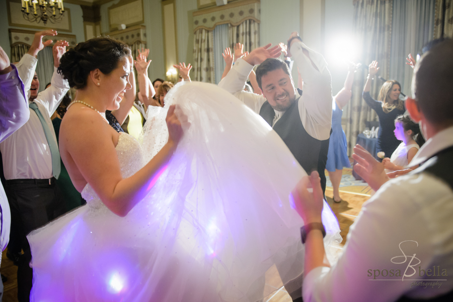 A happy and fun loving bride and groom party on the dance floor at the Westin Pointsett Hotel.