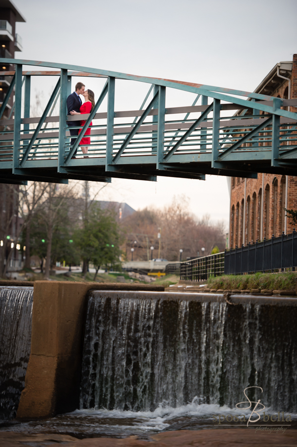 The soon-to-be newlyweds share a kiss on the walking bridge across the Reedy River.