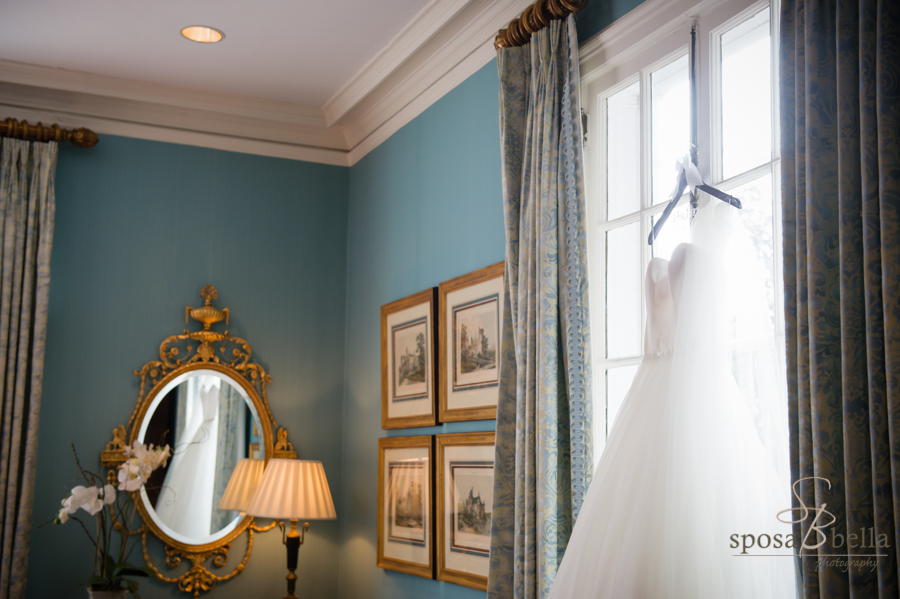 A wedding dress hangs in the window at the Poinsett Club. Notice the reflection on the dress in the mirror. Greenville, SC 2017