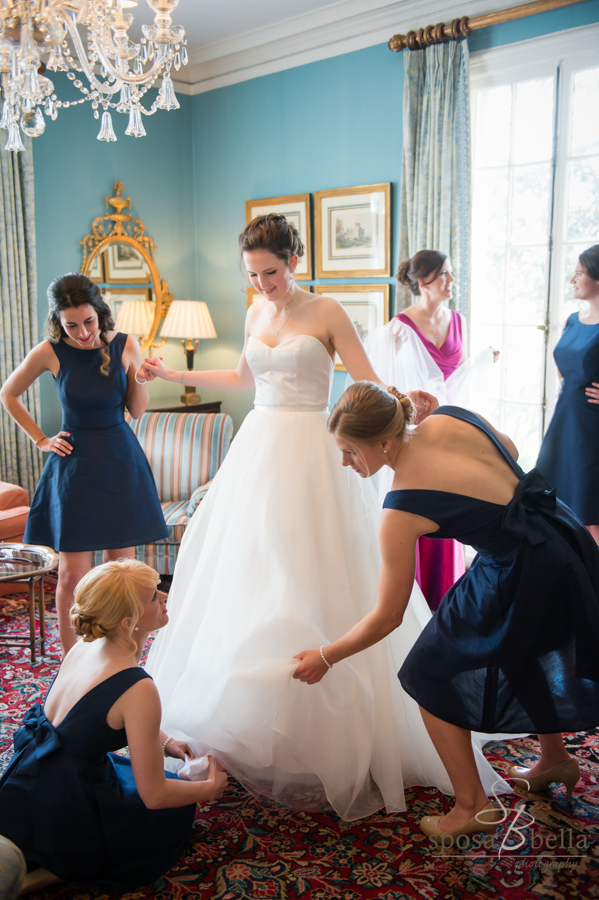 A bride puts on her shoes...with assistance from her bridesmaids in the Friendship room at the Poinsett Club.