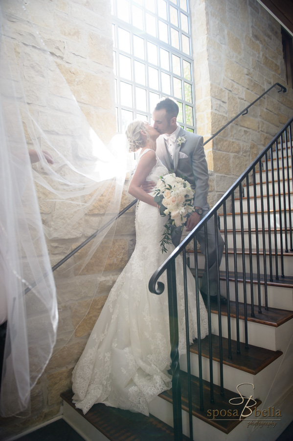 Beautiful back-lit photo of a bride and groom on a staircase.