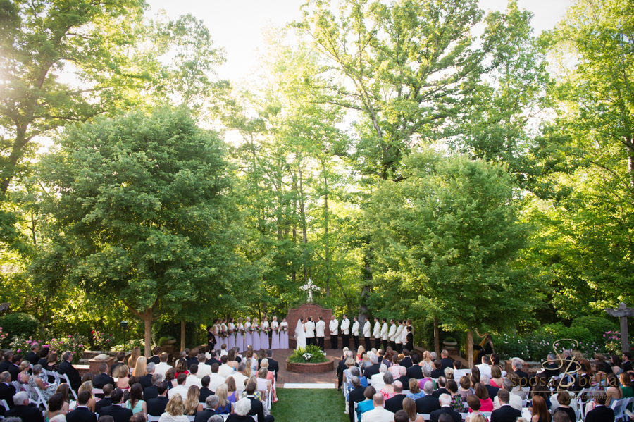 An aerial shot of the entire wedding ceremony with the sun peeking through the treetops. 