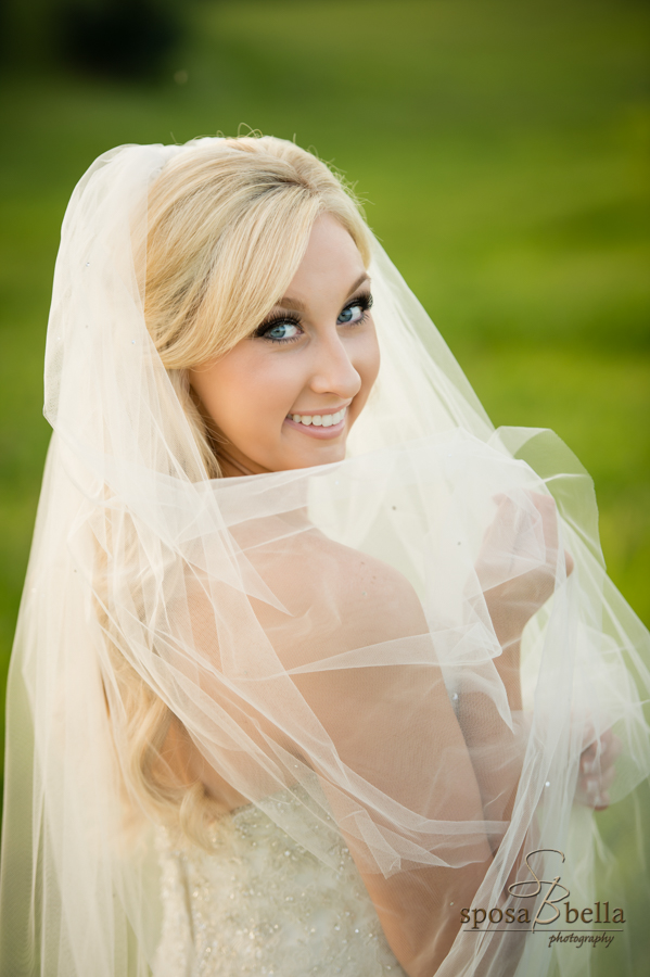 Bride gazes up at the camera while smiling. 