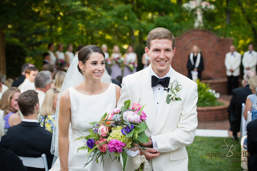 The bride and groom grin as they walk back down the aisle. 