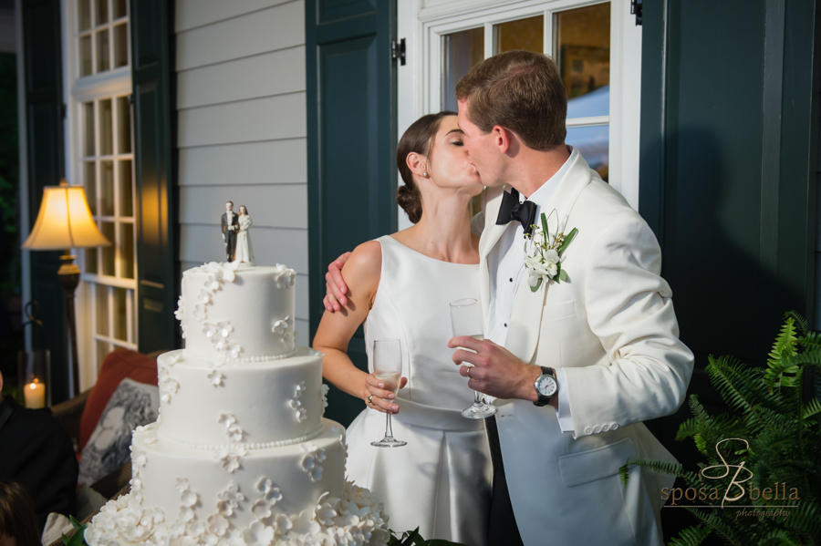 The bride and groom kiss after their toast before cutting the wedding cake. 