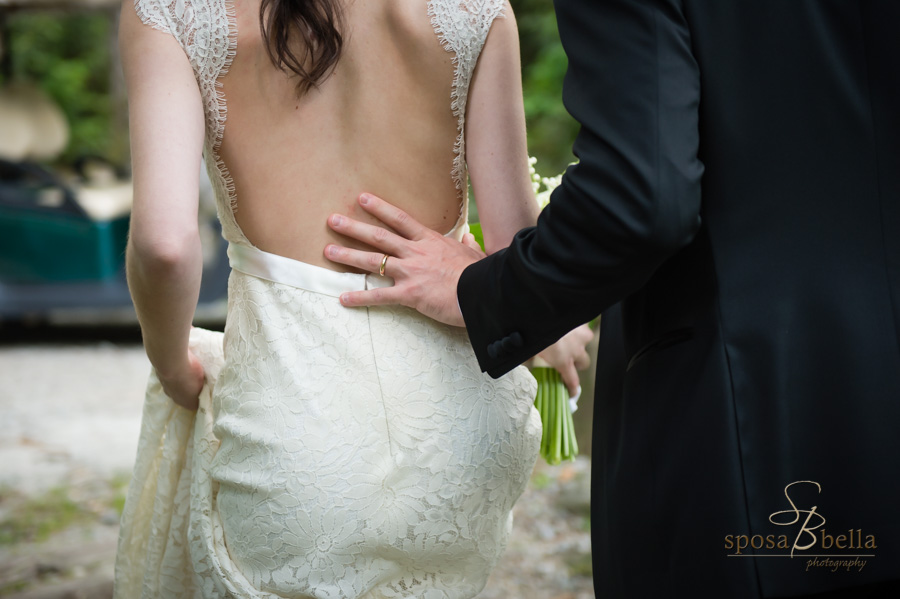 Detail shot of groom's hand on the bride's back featuring his new ring. 