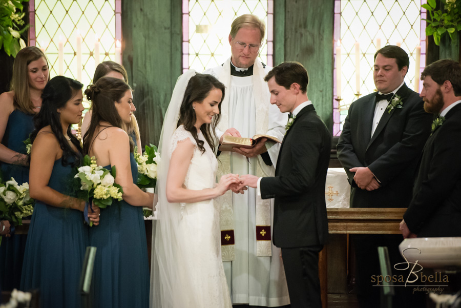 Bride and groom exchange rings during their wedding ceremony. 