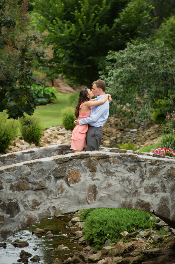 Fiance's kiss on a cobblestone bridge. 