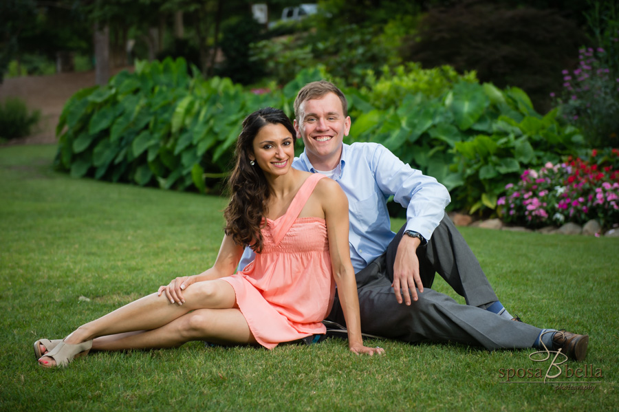 Paul and Seema smile while sitting on the grass at Cleveland Park. 