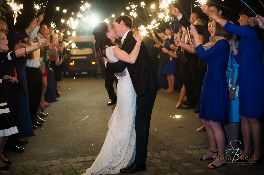 The newlyweds kiss one last time before they leave their reception while surrounded by sparklers. 