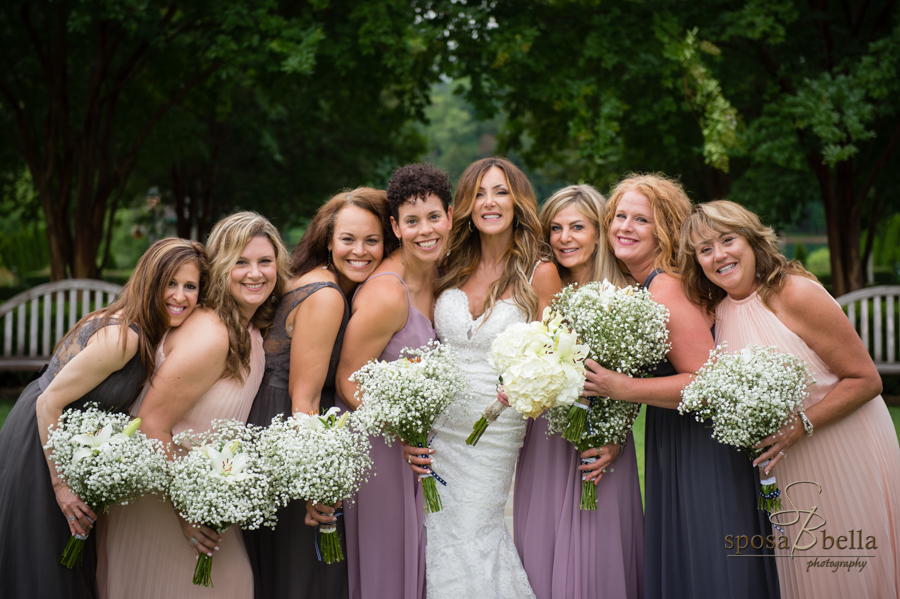 The bride and her bridesmaids all lean in for a group shot. 