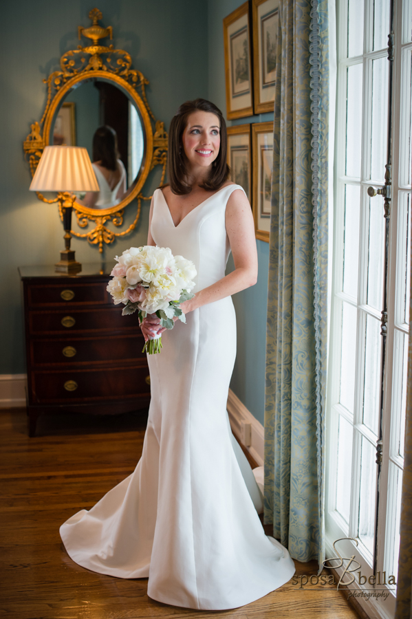Bride gazes out the window of the Poinsett Club as the sun shines on her face. 