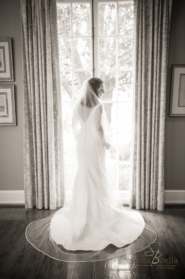 Bride stands at the window of the Poinsett Club. 