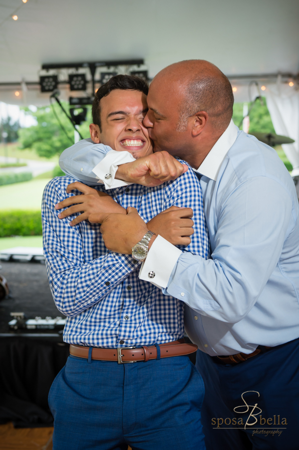 The groom kisses his son on the cheek. 