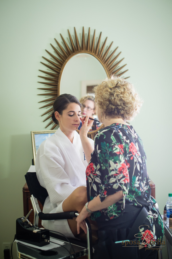 Bride getting her makeup done before her wedding.