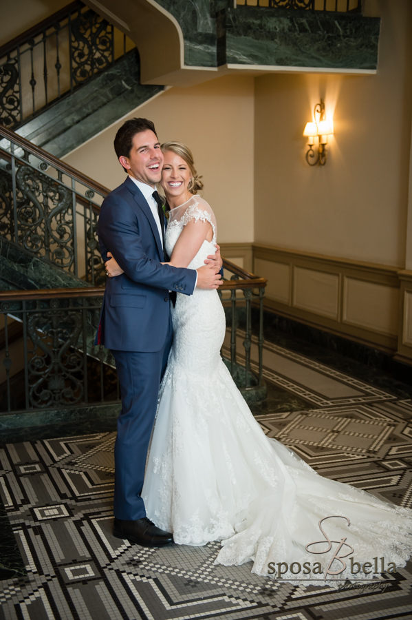 Bride in wedding dress hugs her husband.