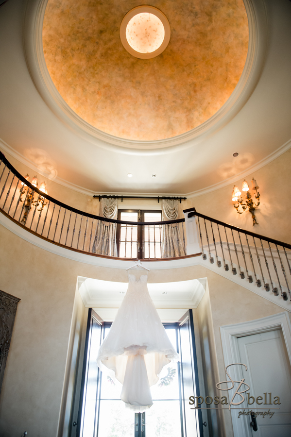 Bridal gown hanging in doorway.